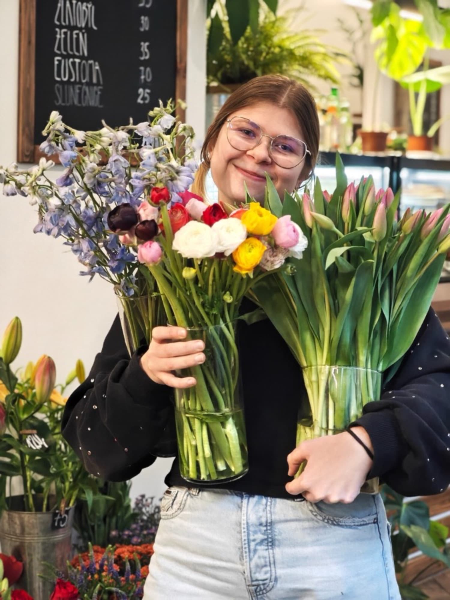 Floristka s vázami plnými tulipánů a lučních květin