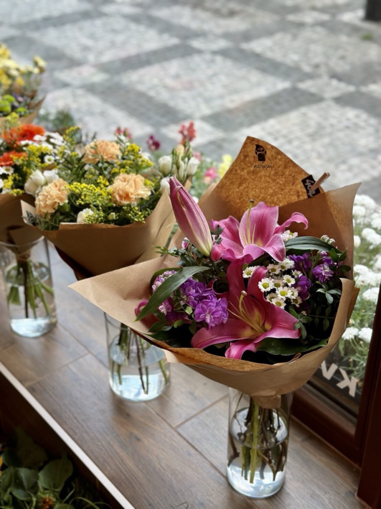 Kytice ve skleněných vázách ve výloze Floristy